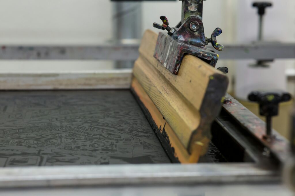 Detailed view of a screen printing setup with a wooden squeegee in Luzern, Switzerland.