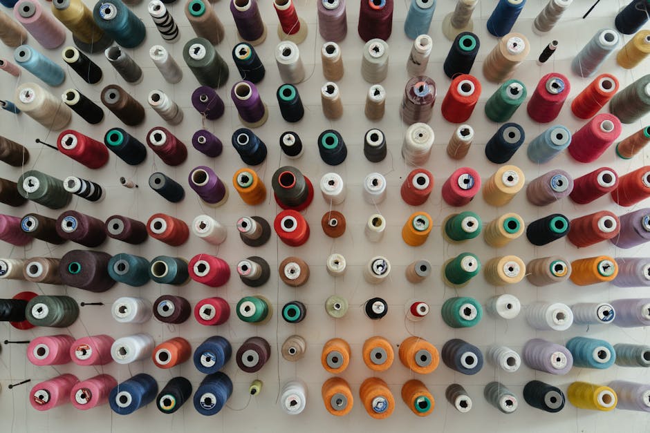 A top-down view of assorted colorful thread spools organized neatly for sewing projects.